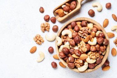 Beyaz arka planda fındık çeşitleri. Badem, fındık, ahşap kasede kaju. Üst görünüm