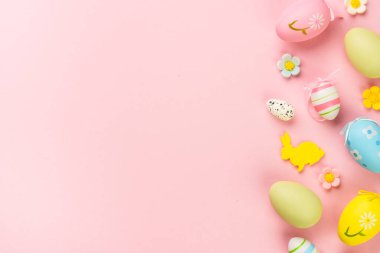 Paskalya yumurtaları ve pembe arka planda tatil süslemeleri. Kopyalama alanı olan düz resim.
