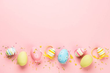 Paskalya yumurtaları ve pembe arka planda süslemeler. Kopyalama alanı olan düz resim.