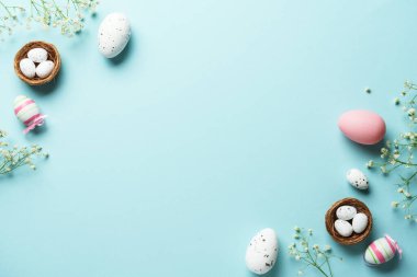 Paskalya arkaplanı, egolar, dekorasyonlar ve çiçekler. Mavi arka planda düz uzandı.