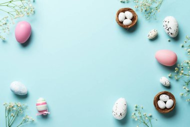 Paskalya arkaplanı, egolar, dekorasyonlar ve çiçekler. Mavi arka planda düz uzandı.