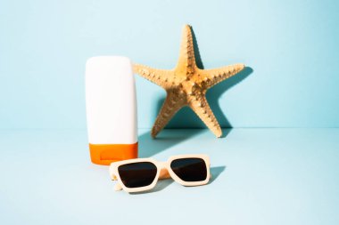 Yaz kavramı. Güneş gözlüğü, güneş kremi ve güneşli gölgeli deniz kabuğu. Moda yaz konsepti.