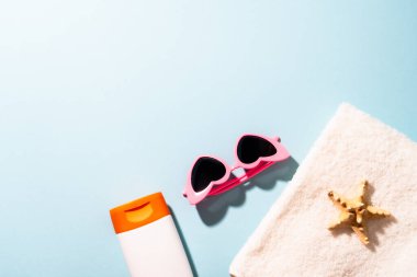 Yaz düzlüğü arka plandaydı. Güneş gözlüğü, güneş kremi ve güneşli gölgeli deniz kabuğu.