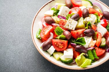 Siyah arka planda Yunan salatası. Üst Manzara. Sağlıklı yiyecekler, Akdeniz diyeti.