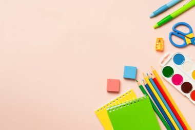 Okul konseptine geri dönelim. Okul kağıtları, renkli arka planda okul malzemeleri. Kopyalama alanı olan düz.