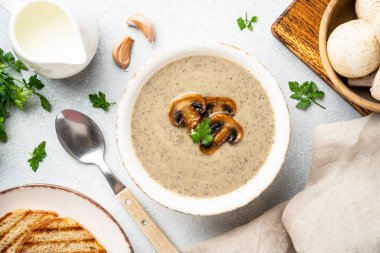Beyaz mutfak masasında mantar çorbası püresi. Sağlıklı vejetaryen yemeği.