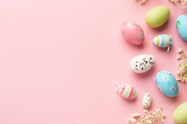 Paskalya yumurtaları pembe arka planda. Renkli yumurtalar, çiçekler. Kopyalama alanı olan düz.