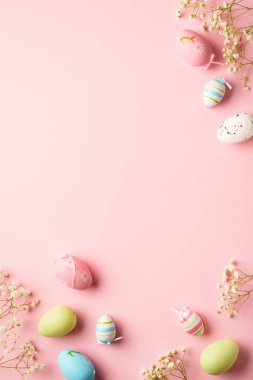Paskalya yumurtaları pembe arka planda. Renkli yumurtalar, çiçekler. Kopyalama alanı olan düz.