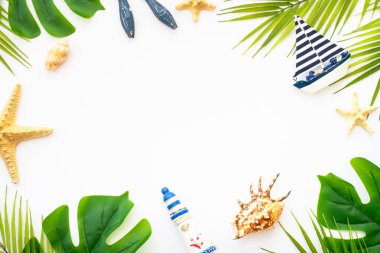 Yaz düzlüğü arka plandaydı. Yaz tatili ve seyahat konsepti. Palmiye yaprakları, deniz kabukları ve beyaz arka planda dekor.