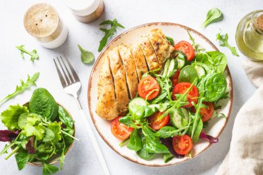 Healthy food plate. Green salad with chicken fillet on white. Top view with copy space.
