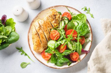 Biftek soslu tavuk salatası ve taze yapraklar ve beyaz üzerine sebze. Kopyalama alanı olan üst görünüm.