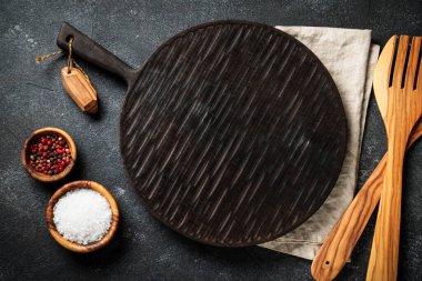 Baharat ve bitkiler, siyah arka planda kesim tahtası. Metin için boşluk ile düz uzandı.