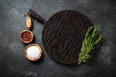 Baharat ve bitkiler, siyah arka planda kesim tahtası. Metin için boşluk ile düz uzandı.
