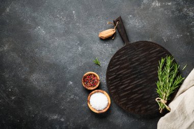 Siyah arka planda bitki ve baharat kesme tahtası. Kopyalama alanı olan üst görünüm.