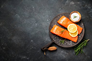 Siyah masada çiğ balık. Limon ve baharatlı somon filetosu. Düz yatıyordu.