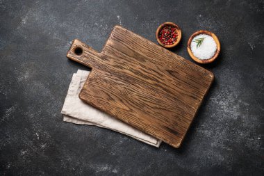 Siyah arka planda baharatlarla kesme tahtası. Kopyalama alanı olan üst görünüm.