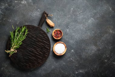 Siyah arka planda bitki ve baharat kesme tahtası. Kopyalama alanı olan üst görünüm.