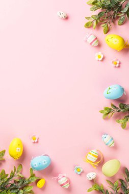 Paskalya yumurtaları ve pembe arka planda tatil süslemeleri. Kopyalama alanı olan düz resim.