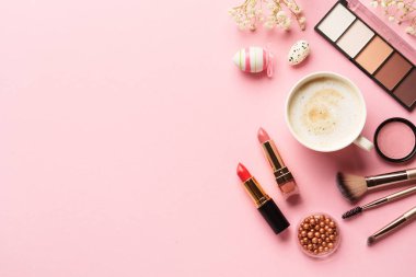 Kadın arka planda yatıyordu. Göz farı, ruj, çiçek ve kahve..