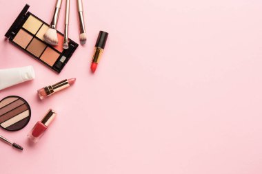 Pembe arka plandaki ürünleri uydur. Göz farı, fosforlu kalem, krem, ruj ve kozmetik fırçalar..