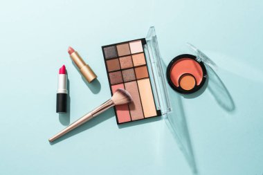 Mavi arka planda profesyonel makyaj ürünleri. Düz yatıyordu.