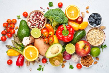 Beyaz arka planda sağlıklı yiyecekler. Taze sebze, meyve, fasulye ve fındık. Yemek pişirme geçmişi.