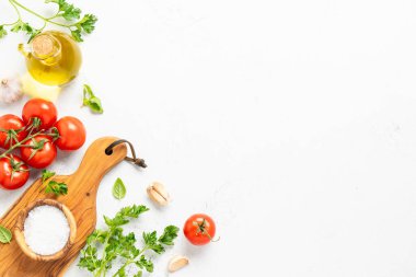 Baharatlar, otlar ve sebzeler ve beyaz mutfak masasında zeytin yağı. Kopyalama alanı olan düz resim.