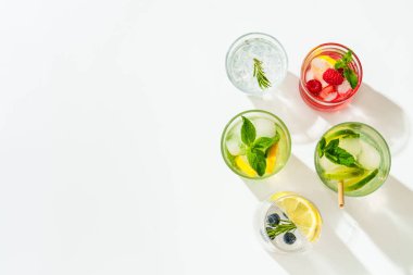 Yaz içkileri, beyaz arka planda renkli kokteyller. Limonata, mojito, ahududu limonatası, tonik su, portakal suyu ve buzlu latte..
