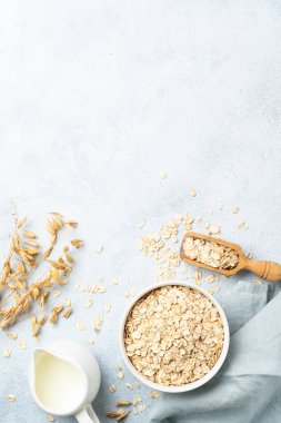 Yuvarlanmış yulaf, süt ve kulak. Metin için boşluk olan beyaz arkaplan üzerindeki üst görünüm.