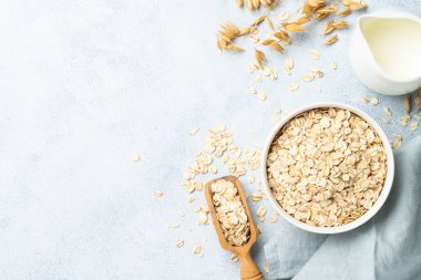 Yuvarlanmış yulaf, süt ve kulak. Metin için boşluk olan beyaz arkaplan üzerindeki üst görünüm.