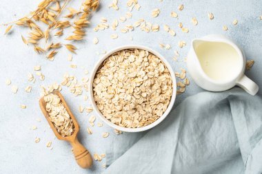 Yuvarlanmış yulaf, süt ve kulak. Beyaz arkaplanda üst görünüm.