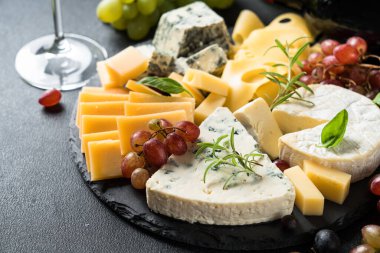 Peynir çeşnili peynir tabağı ve tahta üzerinde üzüm..