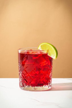 Viski, nar şurubu, acı, limon ve buzlu New Yorker kokteyli. Sert gölgeler, renkli arkaplan