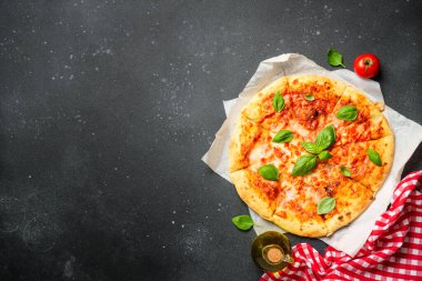Siyah arka planda fesleğen yapraklı pizza Margarita. Üst görünüm, kapat.