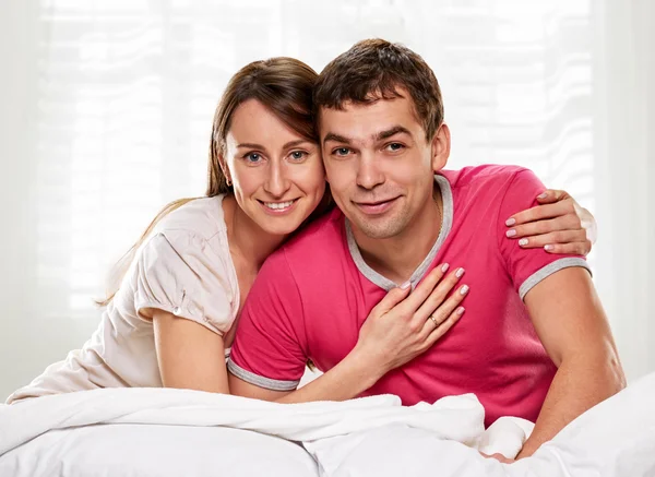 Couple couché au lit souriant — Photo