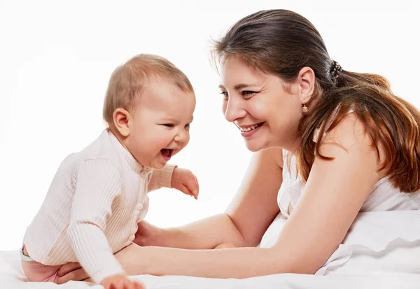 Vrouw en dochter spelen in bed — Stockfoto