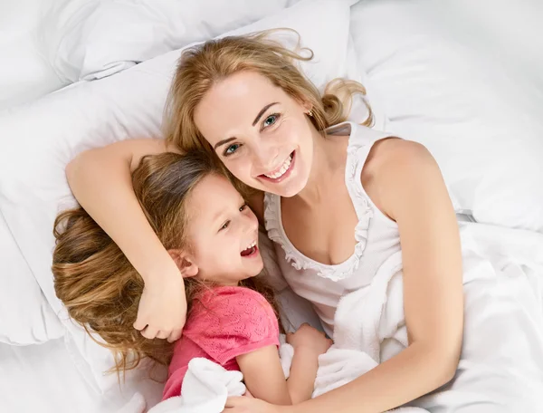 Madre jugando con su hija en la cama —  Fotos de Stock