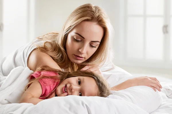 Kobieta i córka leżąc w łóżku — Zdjęcie stockowe