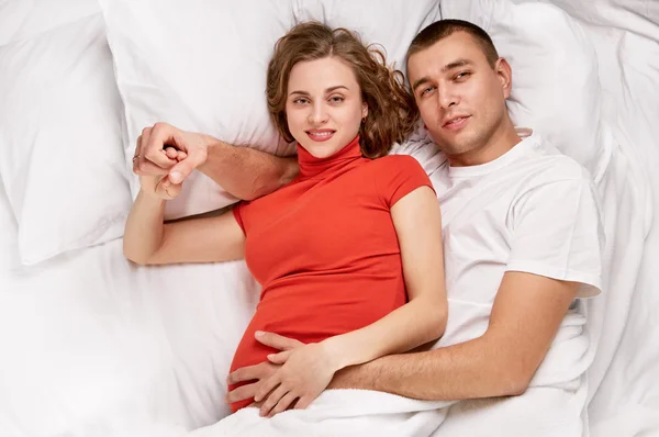 Casal deitado na cama sorrindo — Fotografia de Stock