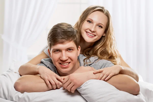 Pareja acostada en la cama sonriendo — Foto de Stock