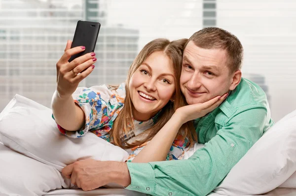Couple heureux avec smartphone prenant selfie — Photo