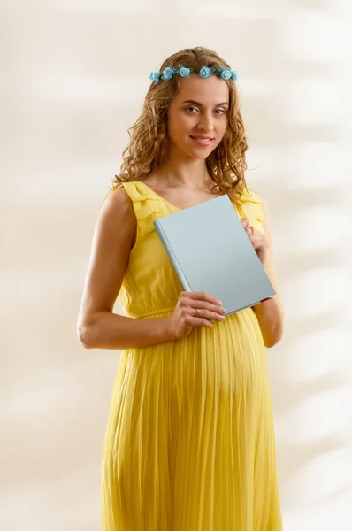 Беременная женщина читает — стоковое фото