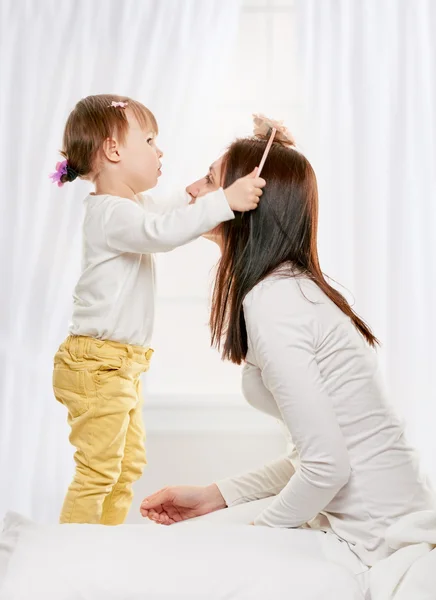 Dotter gör henne mamma hår — Stockfoto