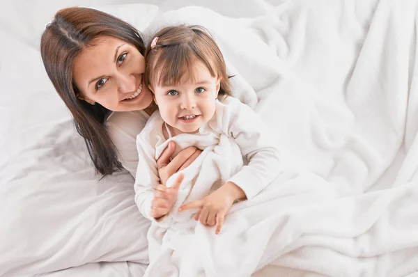 Mamma leker med dotter på sängen — Stockfoto