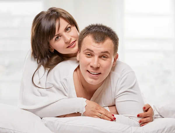 Pareja acostada en la cama sonriendo —  Fotos de Stock