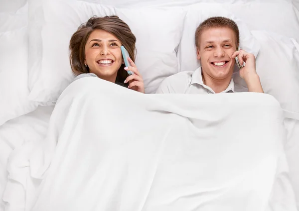Paar liegt und plaudert im Bett — Stockfoto