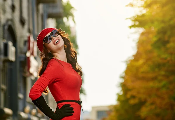 Piękna kobieta w czerwonej sukience na ulicy słońce — Zdjęcie stockowe