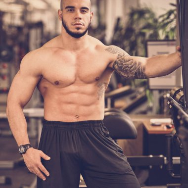 Spor salonunda poz veren vücut geliştirici.