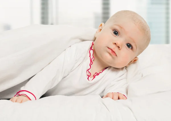 Menina bebê deitado sob cobertor branco — Fotografia de Stock