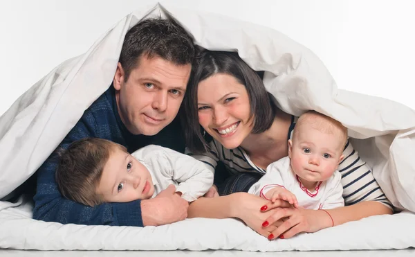 Gelukkig gezin met kinderen in bed — Stockfoto